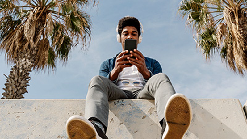 man sat on wall using mobile